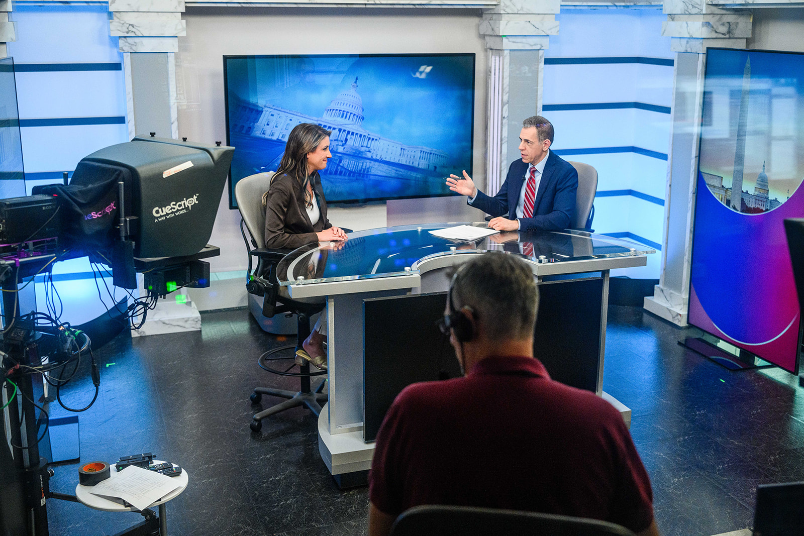 Behind-the-scenes view of Mark Albert coaching a participant during a studio interview