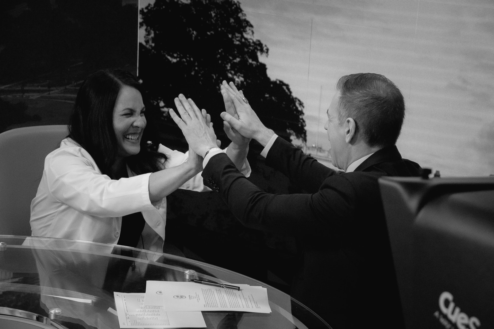Dr. Marga Macias sharing a high five with Mark Albert on a studio set